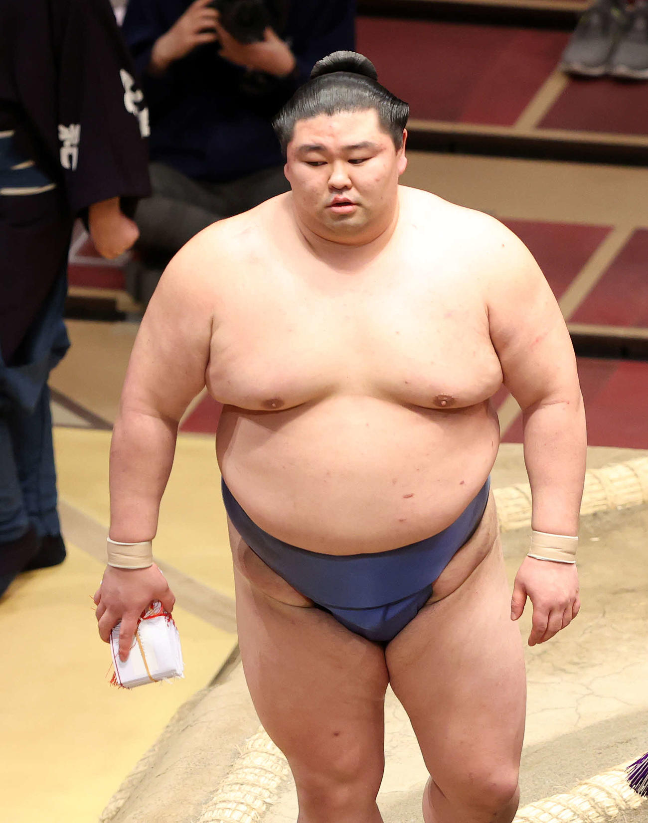 懸賞金の束を手に土俵を引き揚げる正代（撮影・鈴木正人）
