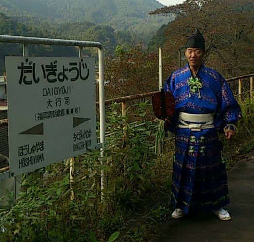大行司駅のホームにて、装束でポーズを取る木村銀治郎