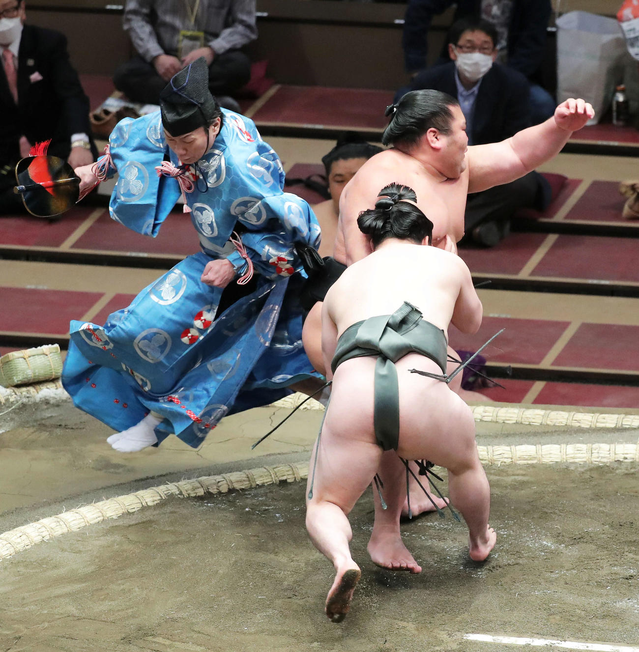 炎鵬（手前）に足を取られる千代ノ皇を避ける行司の式守鬼一郎（撮影・河田真司）