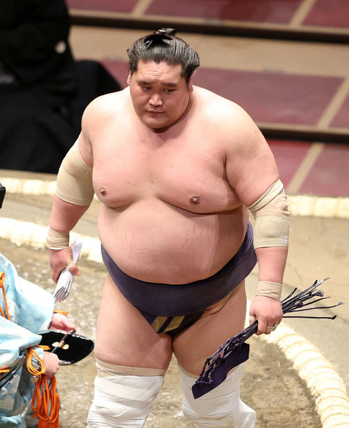 懸賞金の束を手に土俵を引き揚げる照ノ富士（撮影・鈴木正人）