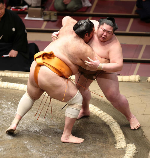 剣翔（右）を寄り切りで破る魁聖（撮影・鈴木正人）