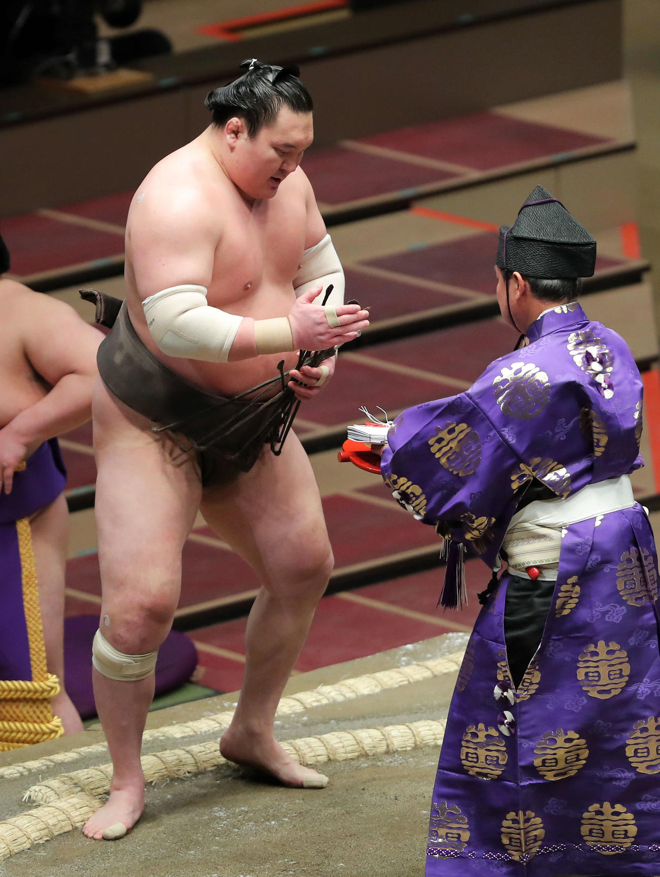立ったまま懸賞金の束を受け取る白鵬（2021年3月15日撮影）