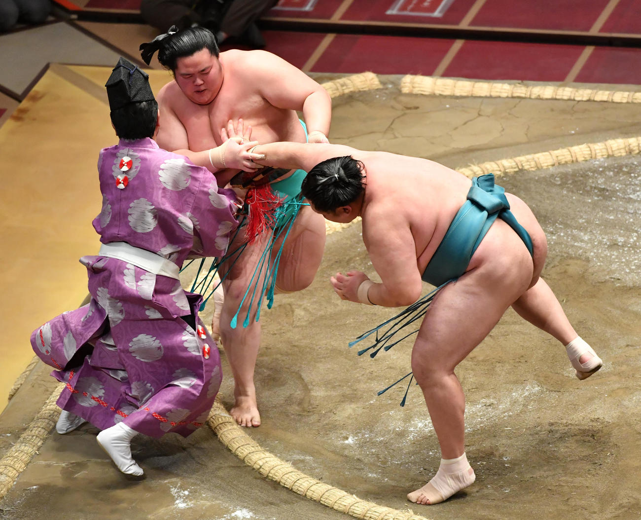 玉鷲（右）は琴ノ若を押し出しで破る。行司の木村寿之介も押し出される（撮影・柴田隆二）