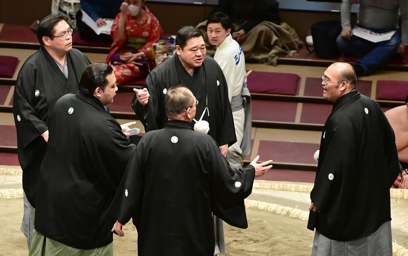 幕下の東照山と千代の勝の一番で物言いがつき協議した結果を同体で取り直しと勘違いしアナウンスしてしまった審判長の東関親方（元高見盛＝右）は再び土俵に上がり審判団と協議の確認をする（撮影・小沢裕）