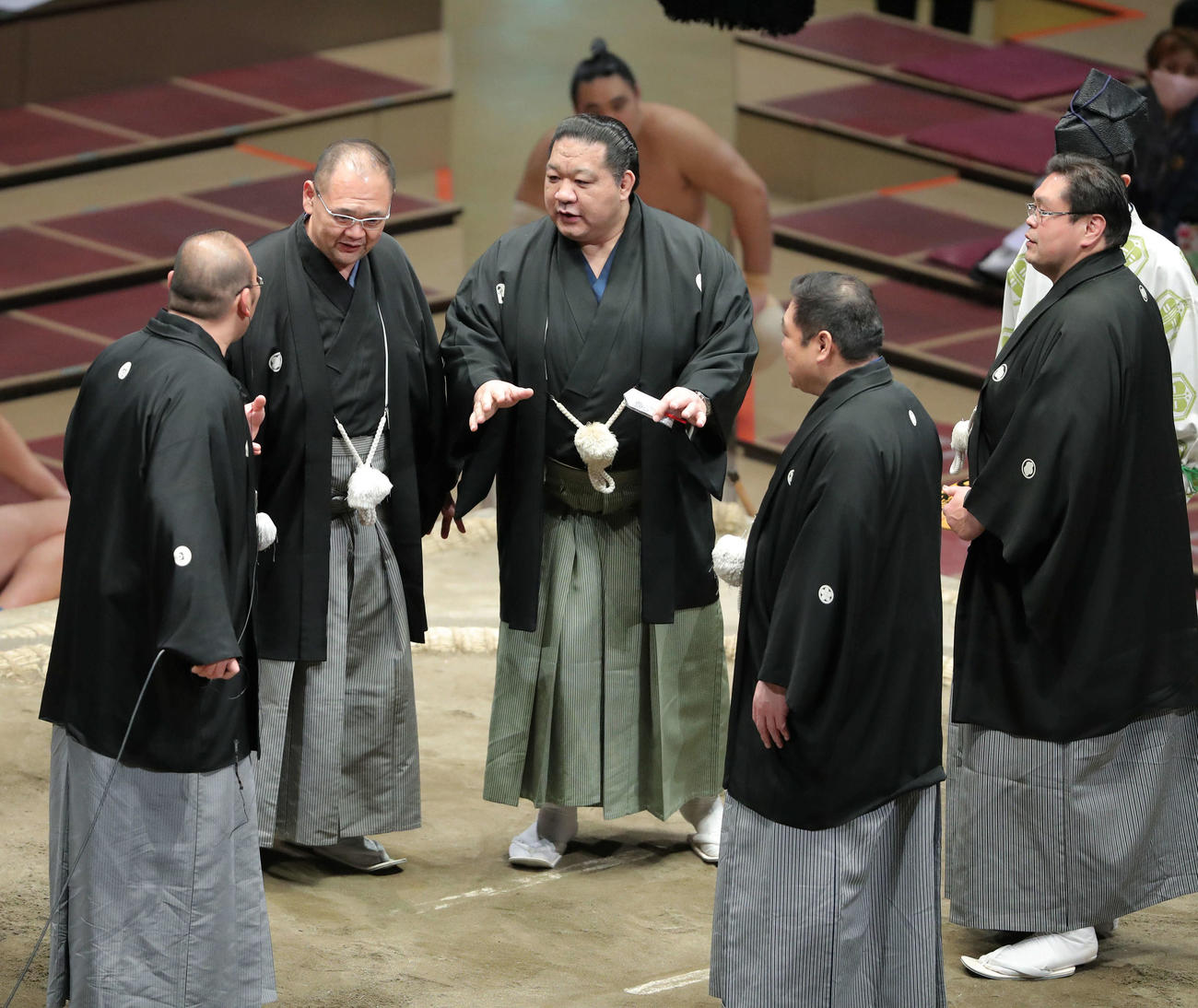 東照山、千代の勝の一番で物言いが付き、一度会場にアナウンスした東関親方（左）だが、湊親方（左から2人目）浅香山親方（中央）ら親方衆に再び土俵上に呼び戻される（撮影・河田真司）
