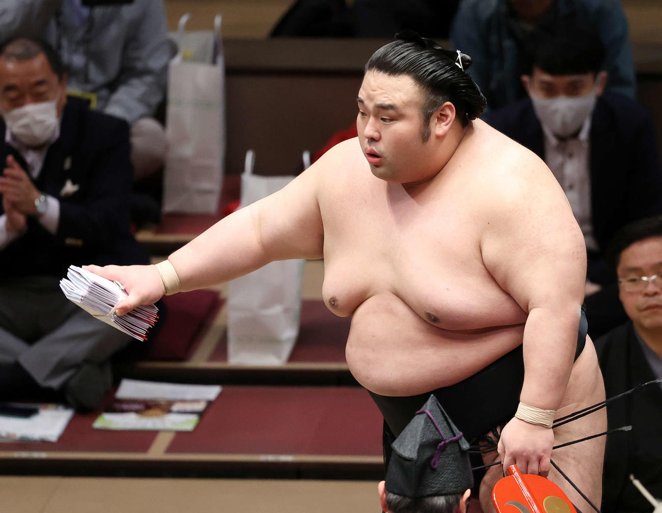 懸賞金の束を手に土俵を引き揚げる貴景勝（撮影・鈴木正人）