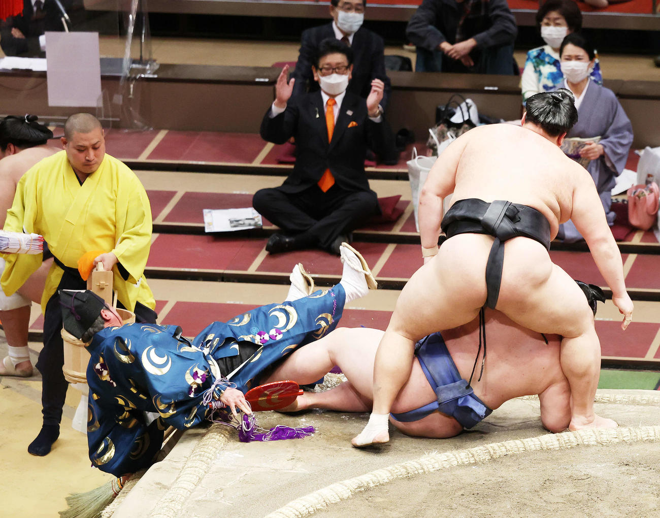 結びの一番で土俵下に落ちる立て行司の式守伊之助（左）（撮影・鈴木正人）