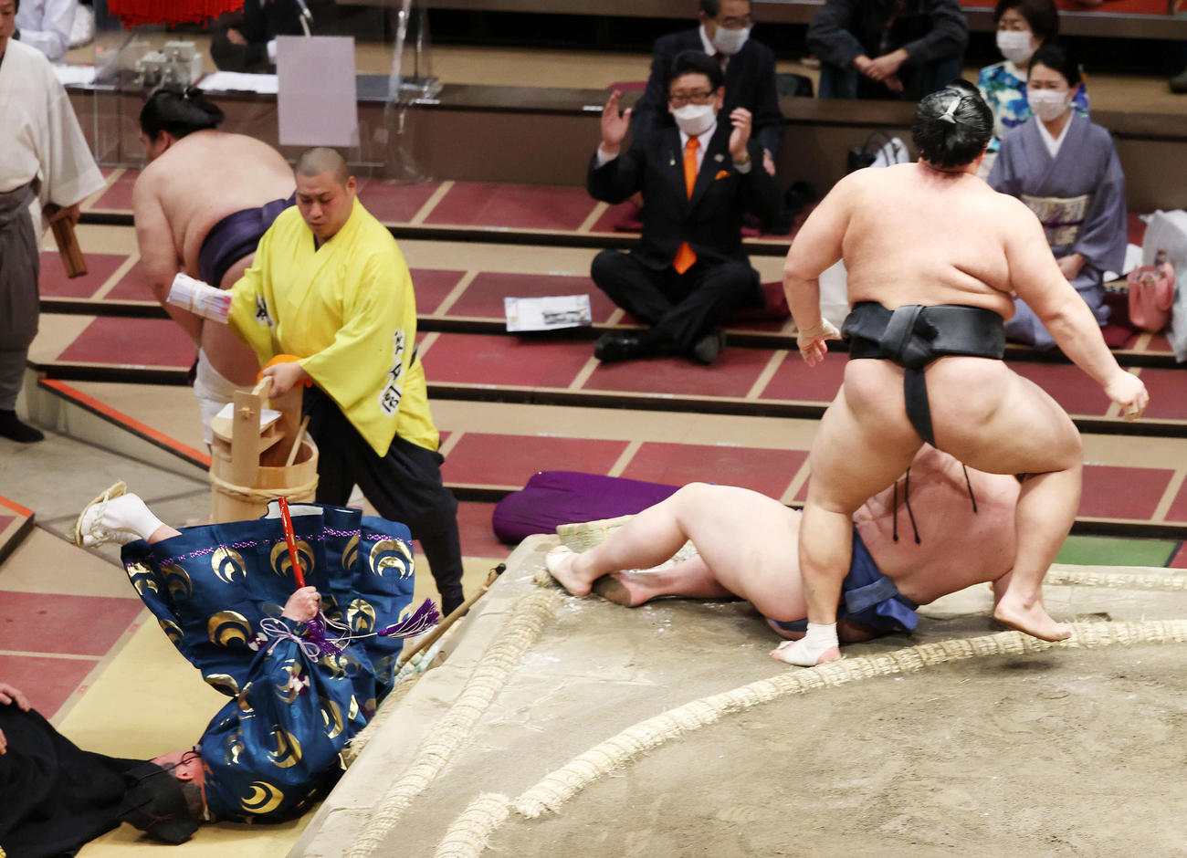 結びの一番で土俵下に落ちる立て行司の式守伊之助（左）（撮影・鈴木正人）