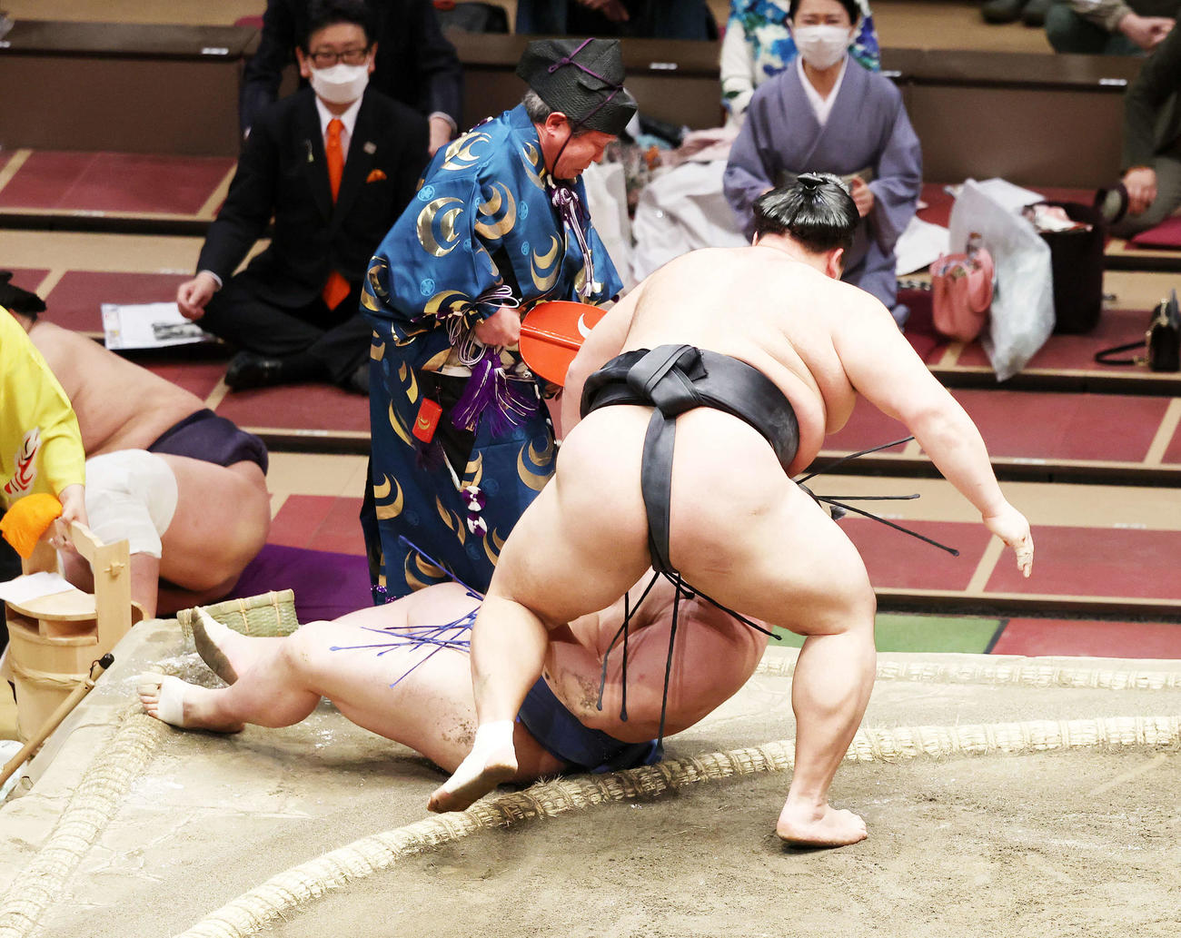 土俵下に落ちる立て行司の式守伊之助（撮影・鈴木正人）