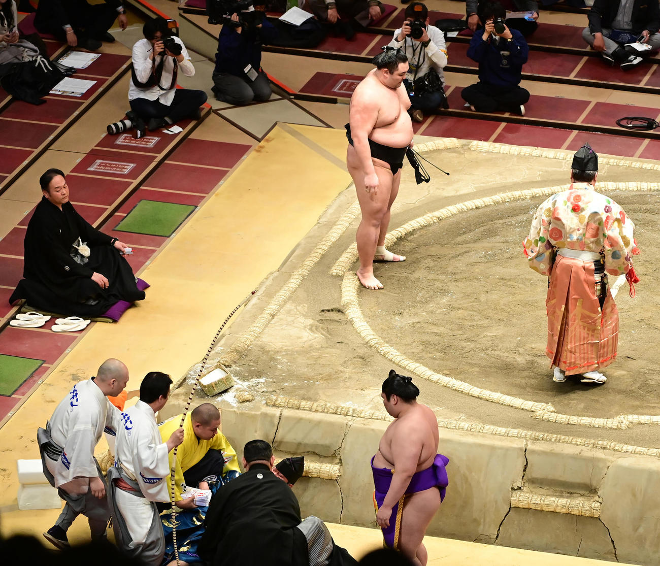 朝乃山は正代を上手投げで破るも、行司の式守伊之助（左下）は巻き添えを食らい土俵下に頭から落ちる。土俵に戻ることができず、控えにいた行司の木村玉治郎（右）が土俵に上がる（撮影・小沢裕）