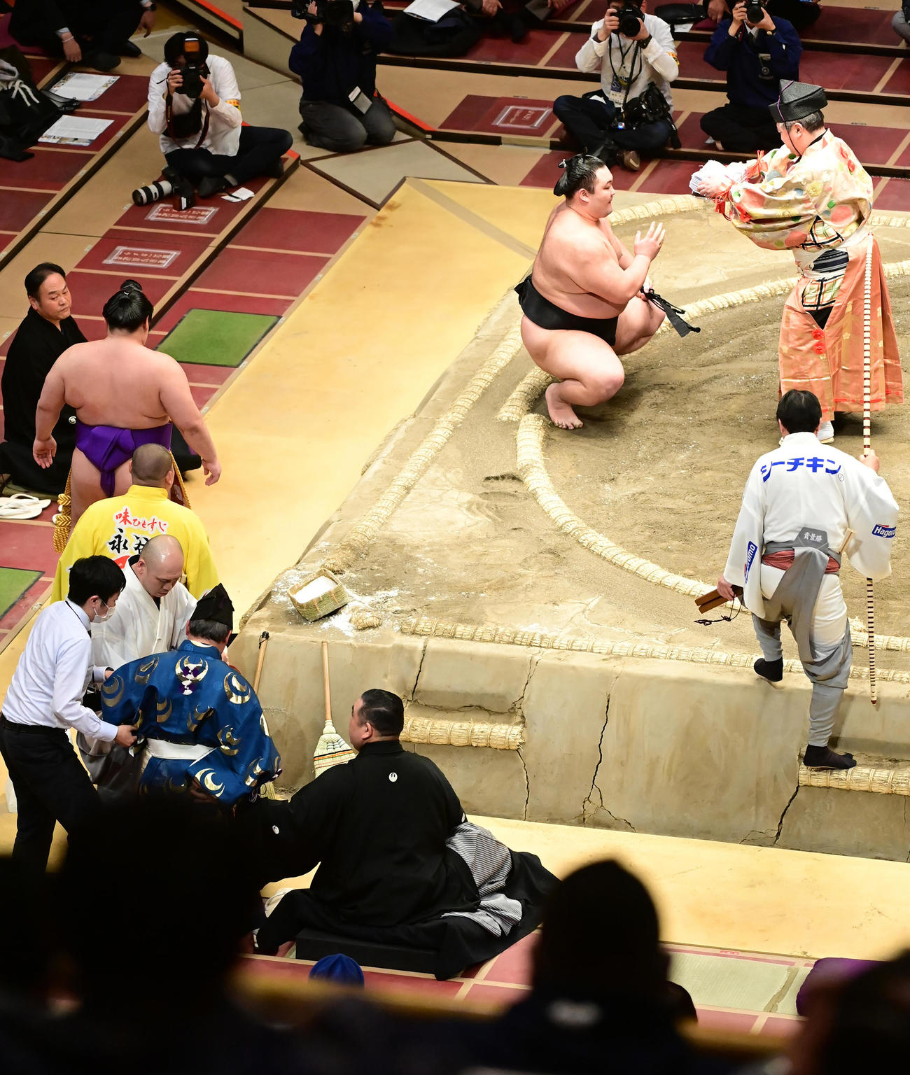 朝乃山は正代を上手投げで破るも、行司の式守伊之助（左下）は巻き添えを食らい土俵下に頭から落ちる。土俵に戻ることができず、控えにいた行司の木村玉治郎（右）が土俵に上がり、朝乃山に勝ち名乗りを告げる（撮影・小沢裕）