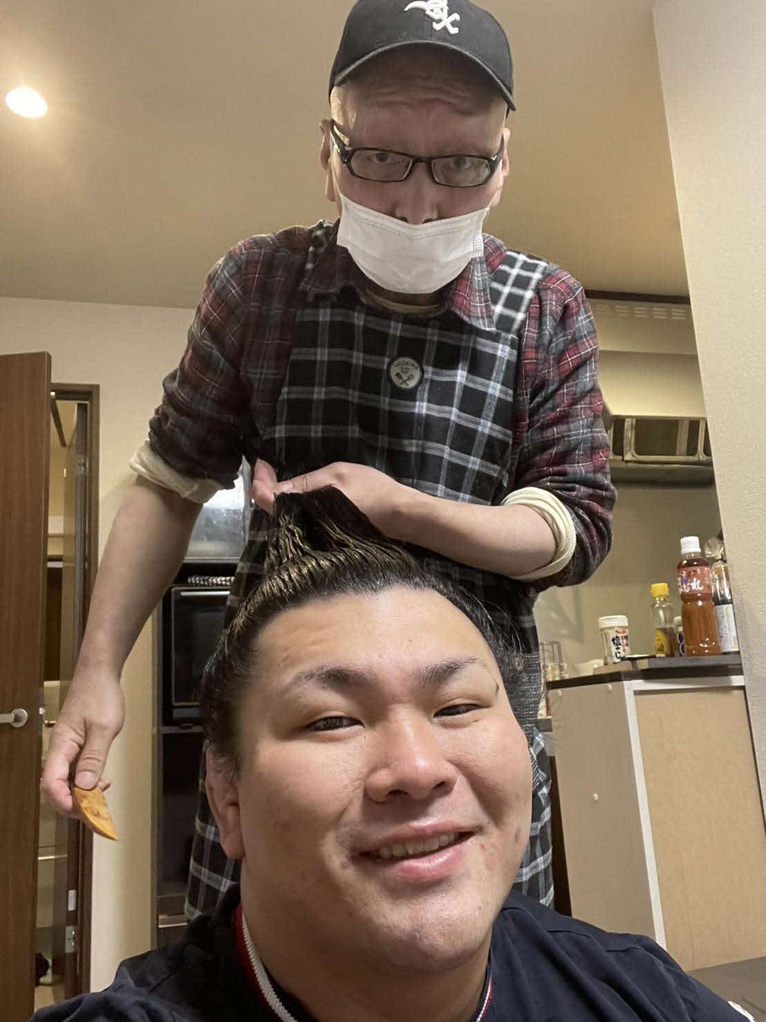 照強のまげを結う床淀。床淀が定年を迎えるため、記念に照強が自撮りした