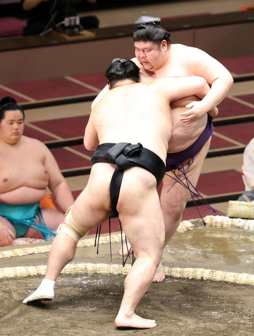 明瀬山(後方)を寄り切りで破る隠岐の海(撮影・鈴木正人)