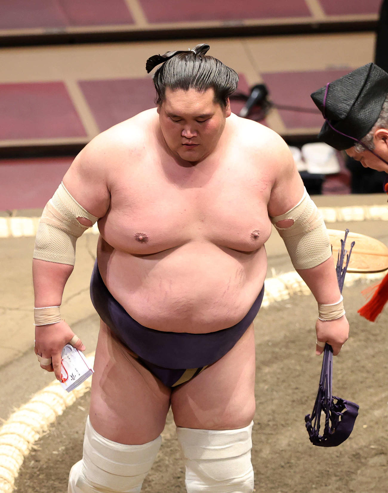 懸賞金の束を手に土俵を引き揚げる照ノ富士（撮影・鈴木正人）