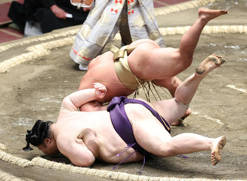 明瀬山（手前）を下手投げで破る石浦（撮影・河田真司）