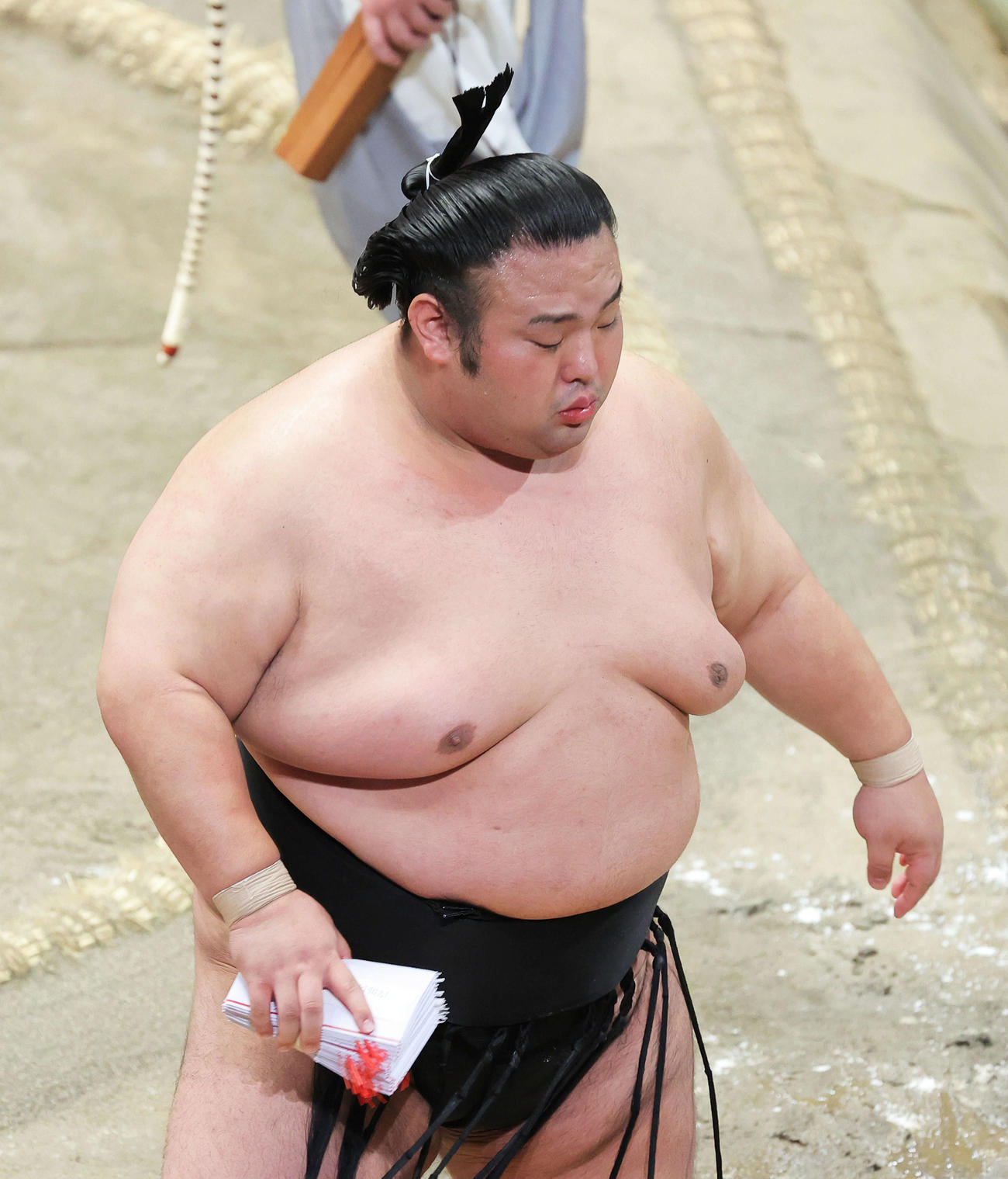 阿武咲を押し出しで破り、懸賞金の束を手に土俵から引き揚げる貴景勝（撮影・河田真司）