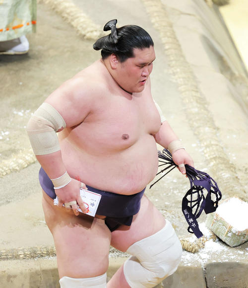 霧馬山を寄り切りで破り、懸賞金の束を手に土俵から引き揚げる照ノ富士(撮影・河田真司)