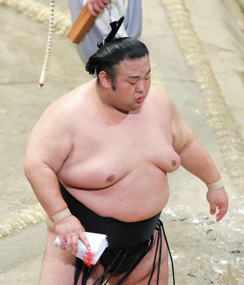 阿武咲を押し出しで破り、懸賞金の束を手に土俵から引き揚げる貴景勝(撮影・河田真司)