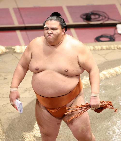 懸賞金の束を手に土俵を引き揚げる御嶽海(撮影・鈴木正人)