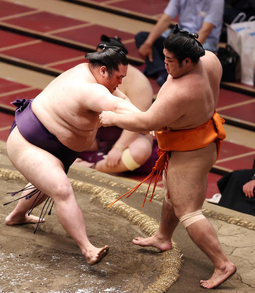志摩ノ海（右）を寄り切りで破る大奄美（撮影・狩俣裕三）