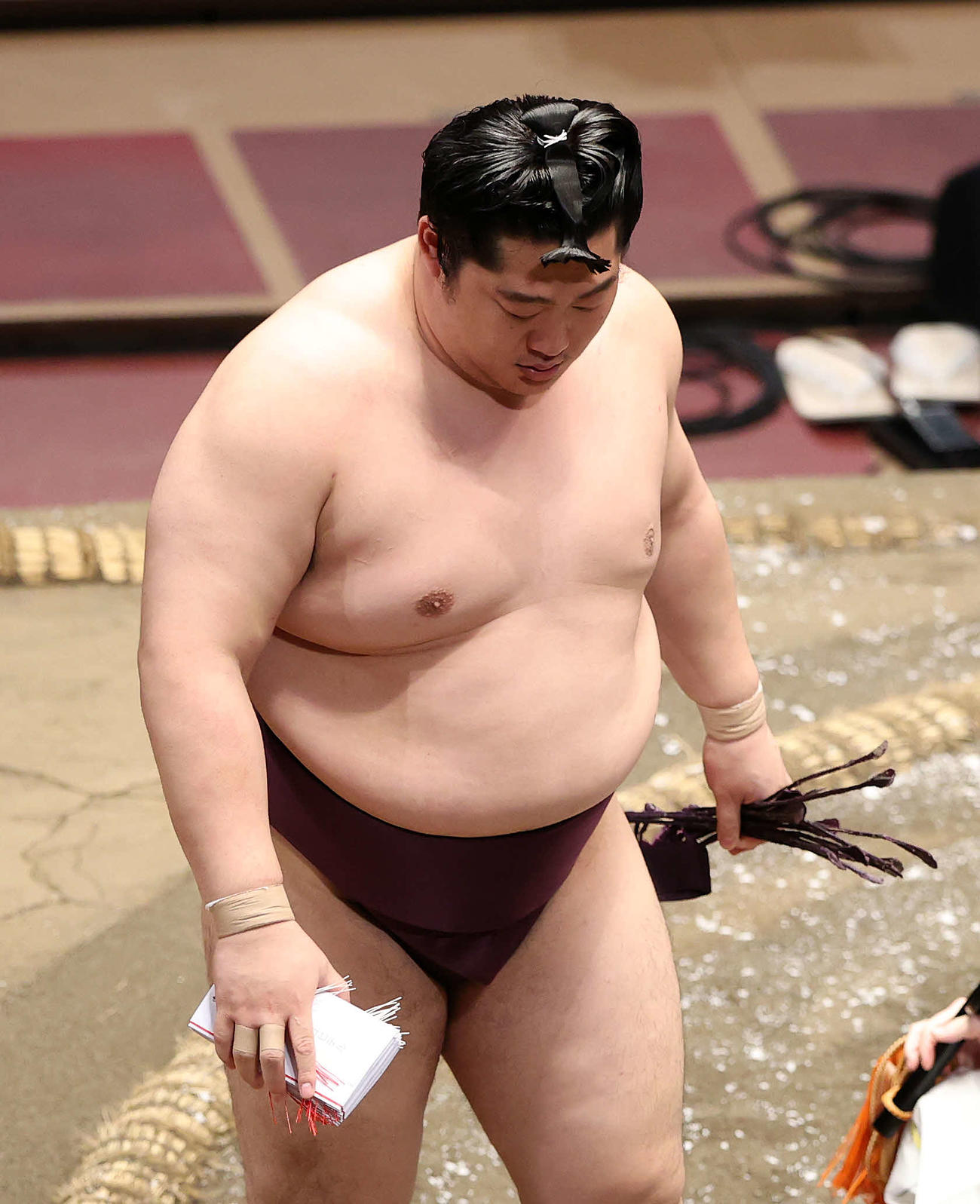 懸賞金の束を手に土俵を引き揚げる遠藤（撮影・鈴木正人）