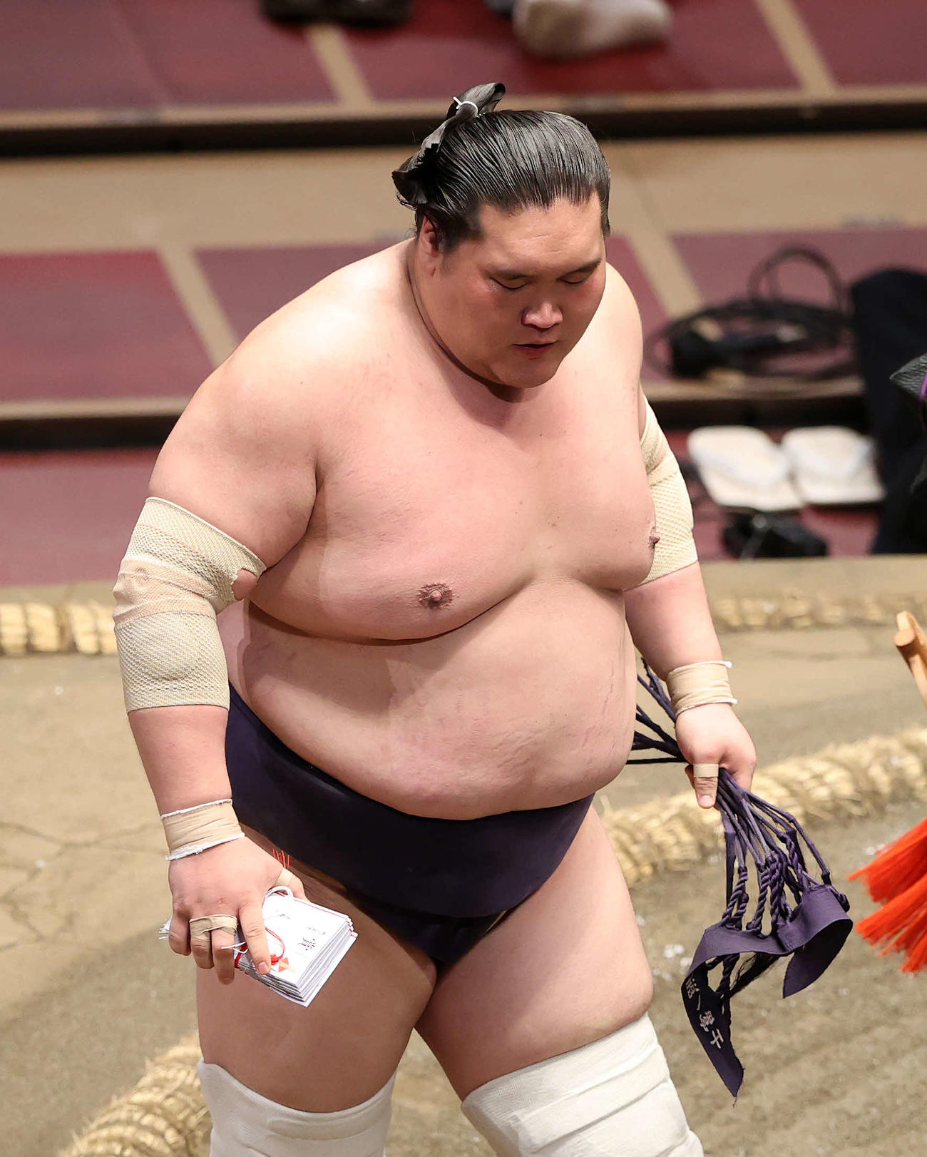 懸賞金の束を手に土俵を引き揚げる照ノ富士（撮影・鈴木正人）