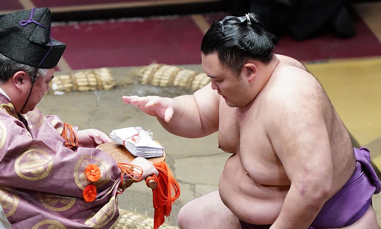 隆の勝をすくい投げで破り、懸賞金を受け取る朝乃山（撮影・菅敏）