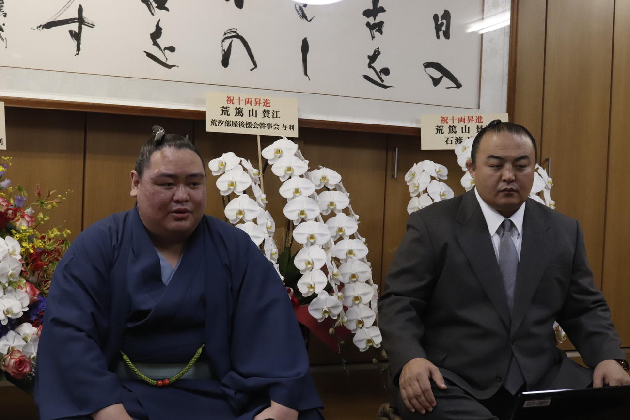 名古屋場所での新十両昇進が決まり、都内の部屋でリモートでの会見に臨む荒篤山（左）と師匠の荒汐親方（日本相撲協会提供）