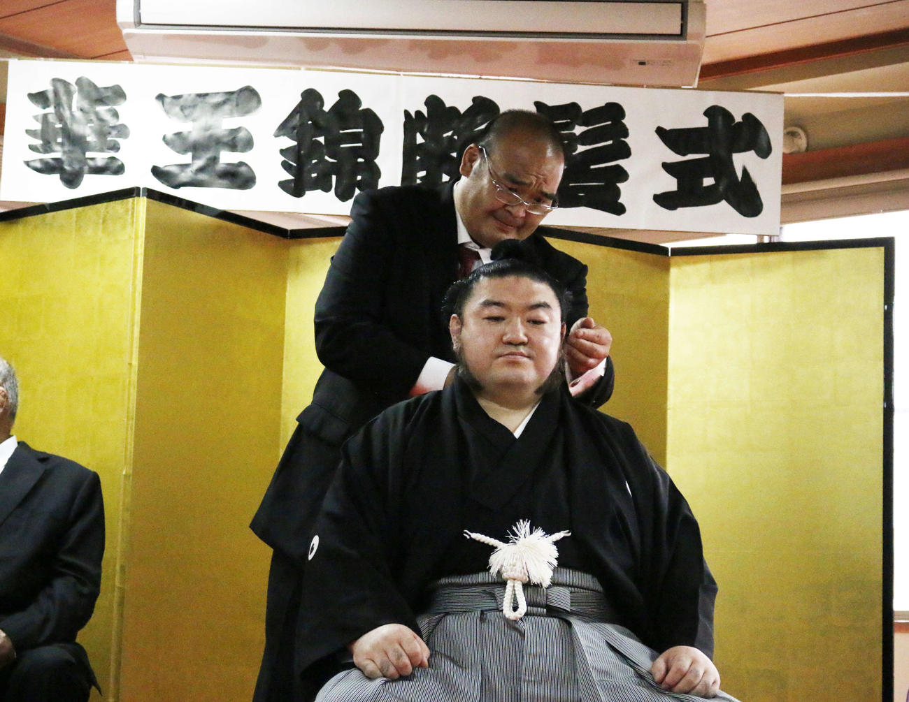 東京・墨田区の旧東関部屋にて行われた華王錦（手前）の断髪式で、はさみを入れる元小結高見盛の東関親方