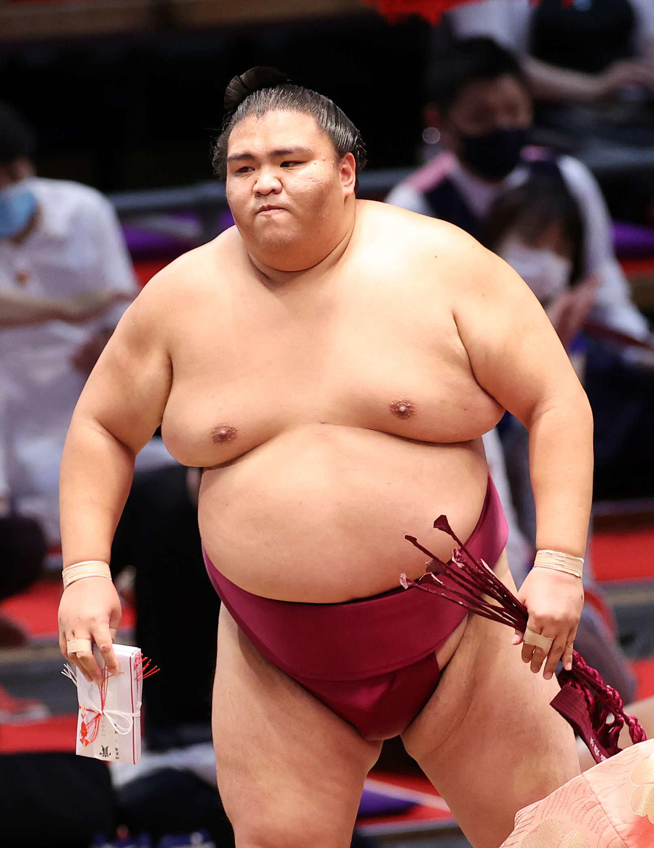 懸賞金の束を手に土俵を引き揚げる御嶽海（撮影・鈴木正人）