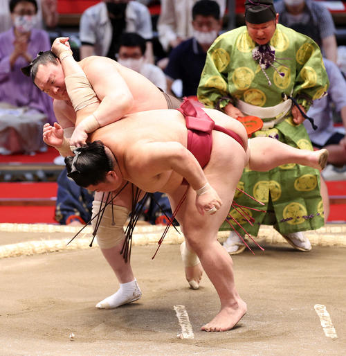 大栄翔（手前）をすくい投げで破る白鵬（撮影・鈴木正人）