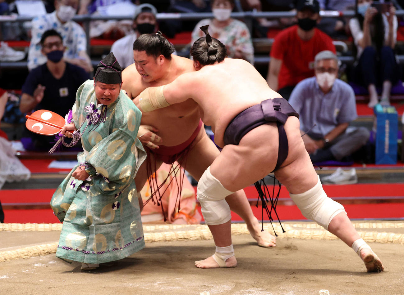 大栄翔（右）を寄り切りで破る照ノ富士、行司は式守伊之助（撮影・鈴木正人）