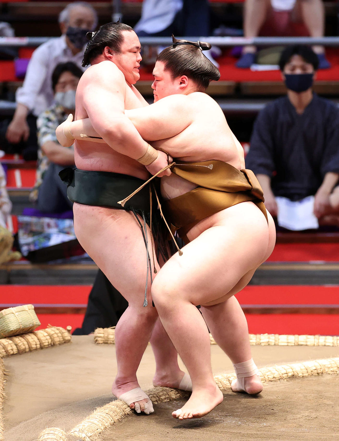 魁勝（左）を寄り切りで破る王鵬（撮影・鈴木正人）
