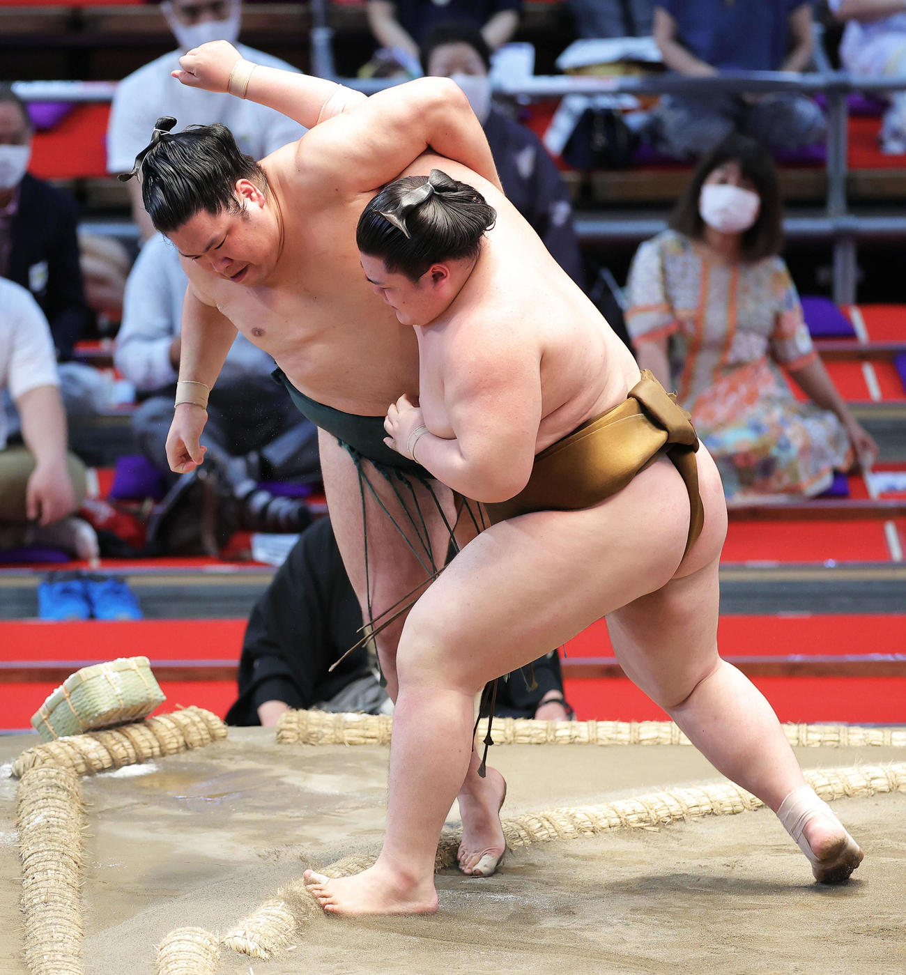 錦木（左）を寄り切りで破る王鵬（撮影・河田真司）