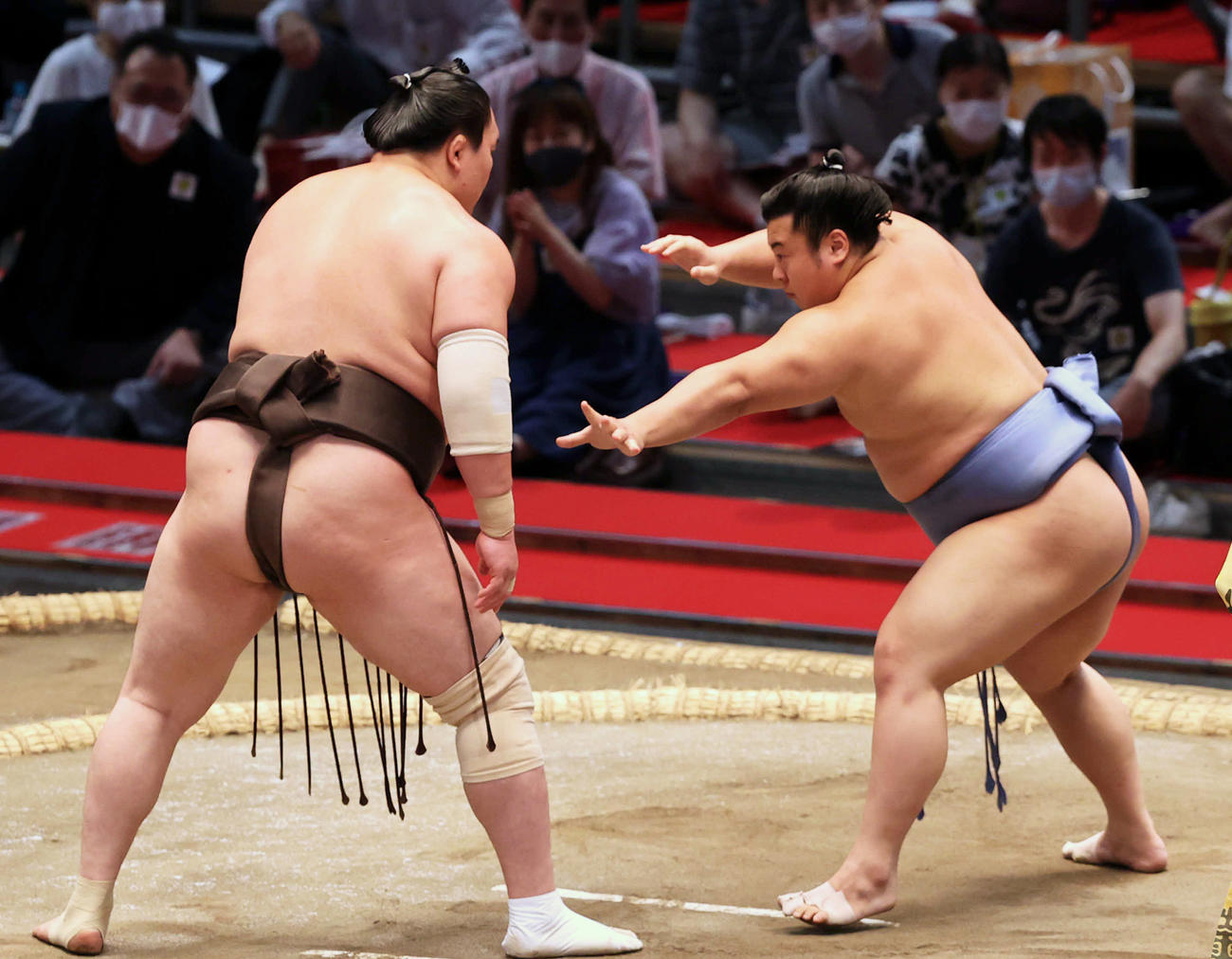 腕を伸ばし白鵬との間合いをはかる翔猿（右）（撮影・渦原淳）