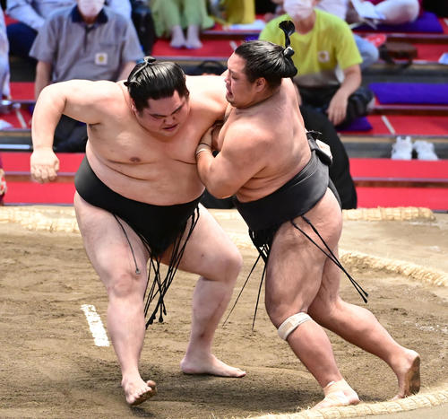 松鳳山（右）の攻めをこらえる大奄美（撮影・小沢裕）