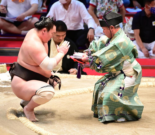 全勝を守った白鵬（左）は懸賞金を受け取る（撮影・小沢裕）