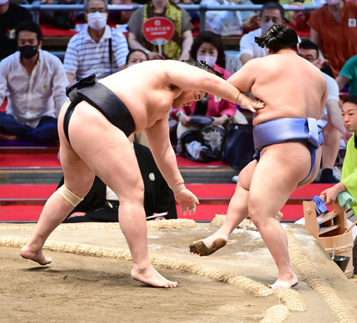 輝（左）は翔猿を押し出しで破る（撮影・小沢裕）