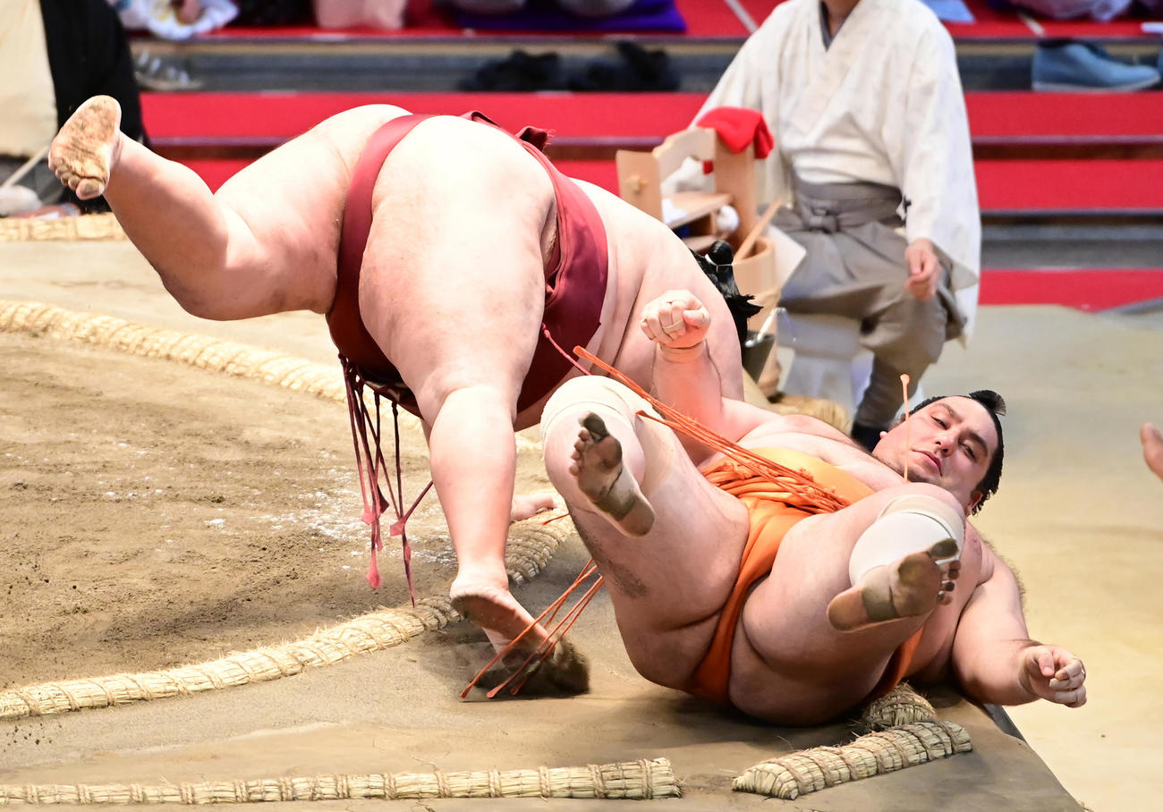 徳勝龍は魁聖（右）をすくい投げで破る（撮影・小沢裕）