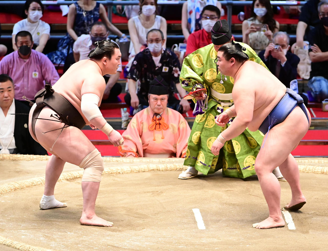 立ち合いで互いに相手の出方をうかがう正代（右）と白鵬（撮影・小沢裕）