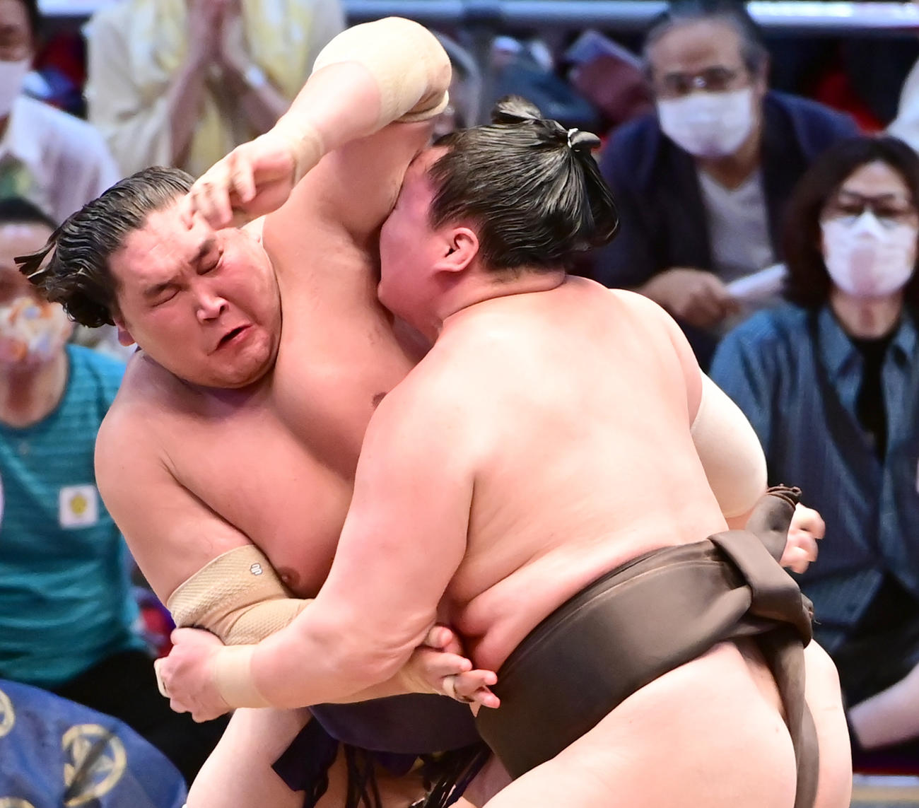 照ノ富士（左）をがっちりとつかまえる白鵬（撮影・小沢裕）