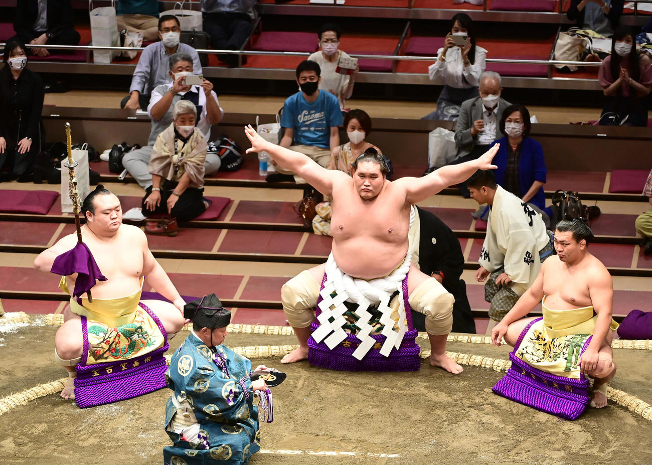 横綱土俵入りに臨む照ノ富士（中央）。行司は式守伊之助、左は太刀持ちの宝富士、右は露払いの照強（撮影・小沢裕）