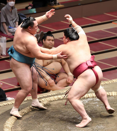 玉鷲（左）を押し出す大栄翔（右）。後方は取組を見つめる高安（撮影・河野匠）