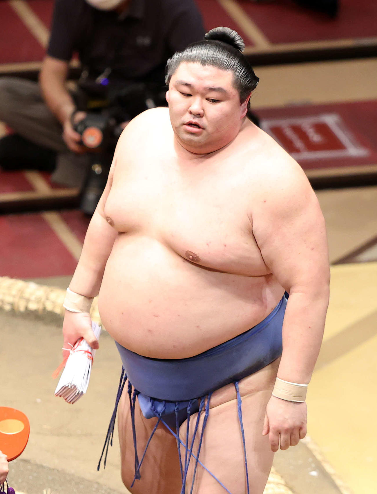 懸賞金の束を手に土俵を引き揚げる正代（撮影・鈴木正人）