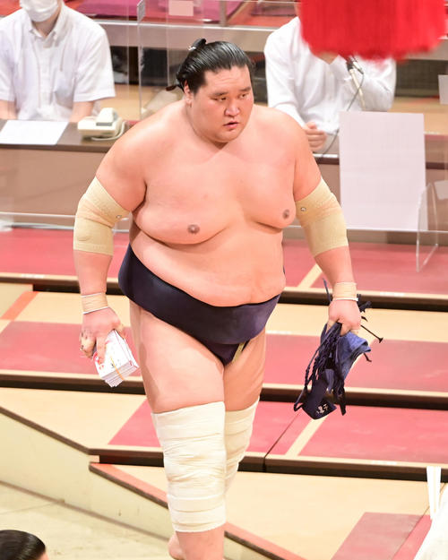 懸賞の束を手に花道を引き揚げる照ノ富士（撮影・小沢裕）