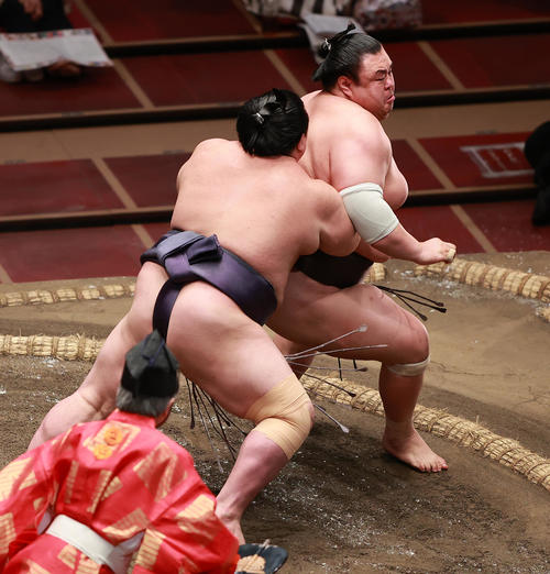 英乃海（奥）を送り出しで破る阿武咲（撮影・野上伸悟）