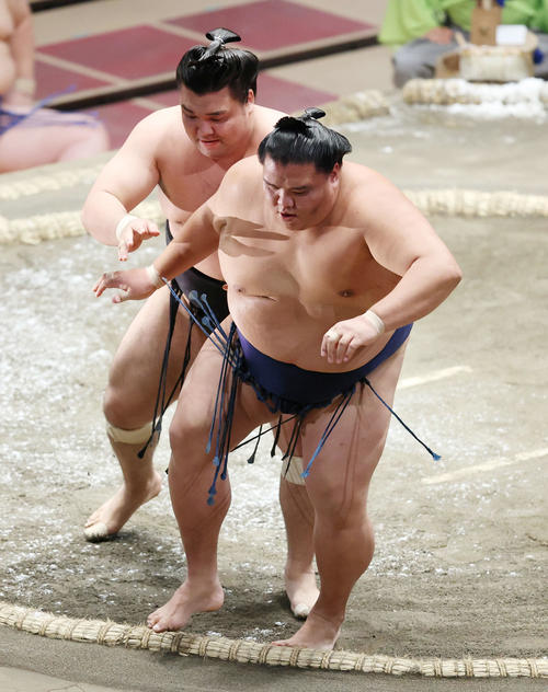 御嶽海（手前）を送り出しで破る霧馬山（撮影・河田真司）
