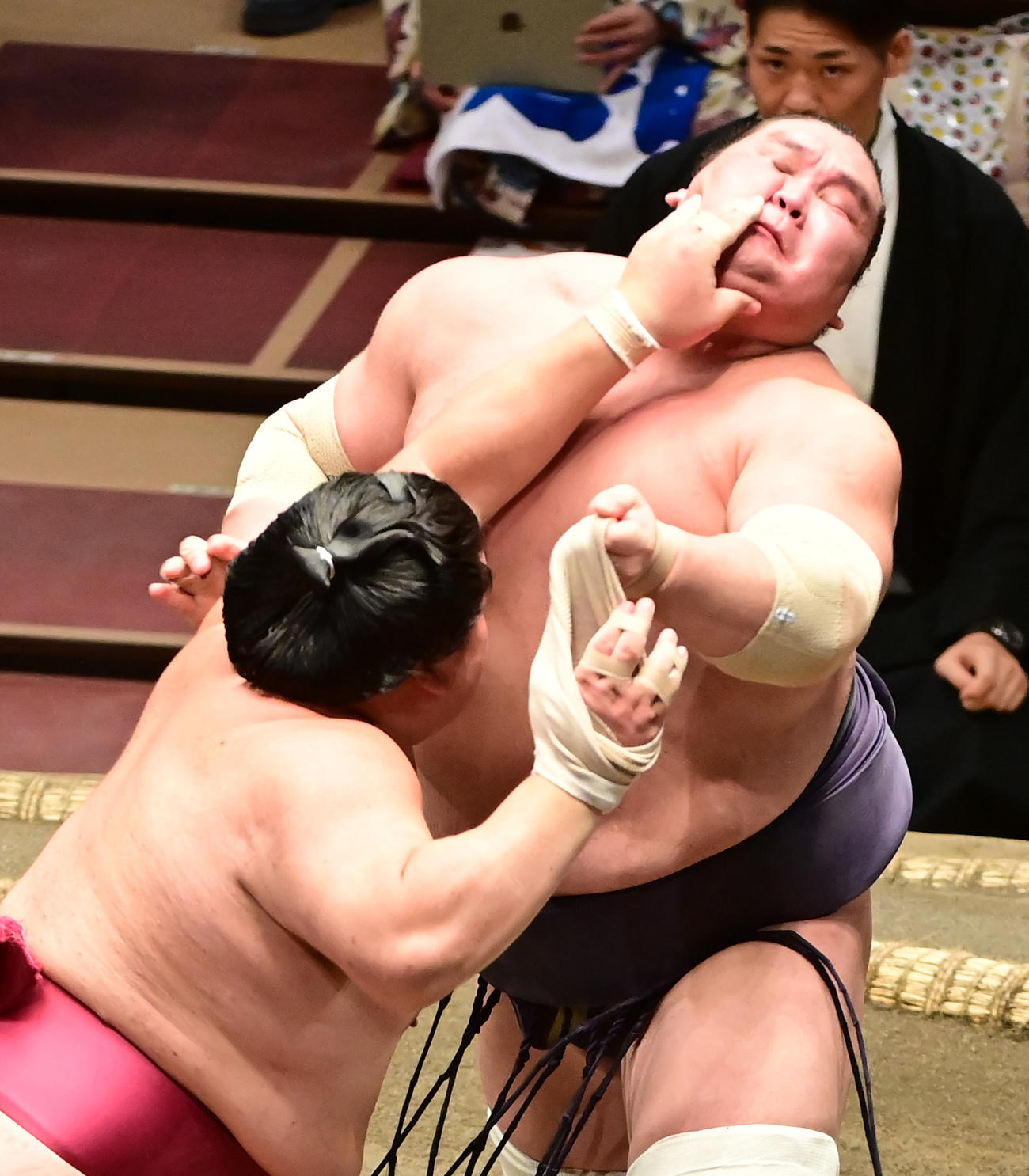 照ノ富士（右）を突き押しで攻める大栄翔。照ノ富士の左手が絡まり大栄翔の右手に巻いていたサポータが外れて宙を舞った（撮影・小沢裕）