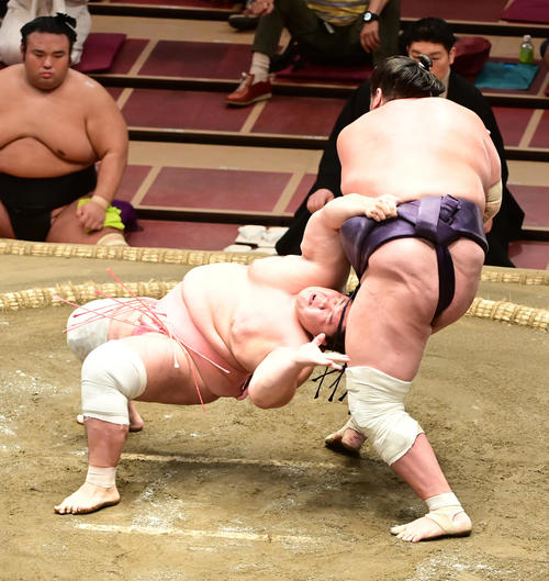照ノ富士（右）の上手投げをまわしをつかんで必死にこらえる宇良（撮影・小沢裕）