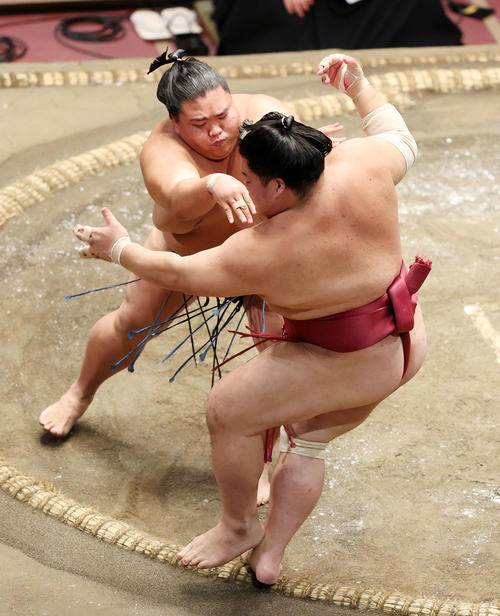 大栄翔（手前）を押し出しで破る御嶽海（撮影・鈴木正人）